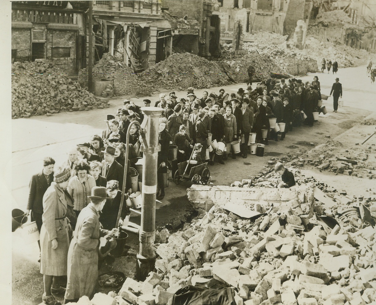 Rush Growler for Water, 4/29/1945. Germany—German civilians line up for supply water from one of few sources in Magdeburg after capture by Allies. Water from the pump is handed out in small rations. Credit –WP- (ACME);