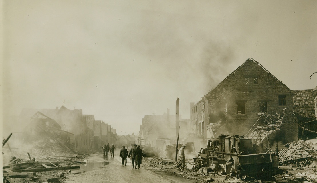 Fire – Everywhere, Fire, 4/2/1945. LESHEIM, GERMANY – It will take a lot of reconstruction to restore this main street in Lesheim to its former prominence. In the midst of the building wreckage, U.S. Army vehicles burn after they were hit by German guns outside the town. Much of the damage was caused when 4.2 shells, stored in the vehicles, were hit by German shells and exploded. Photo by Charles Haacker, Acme War Pool Photographer.;