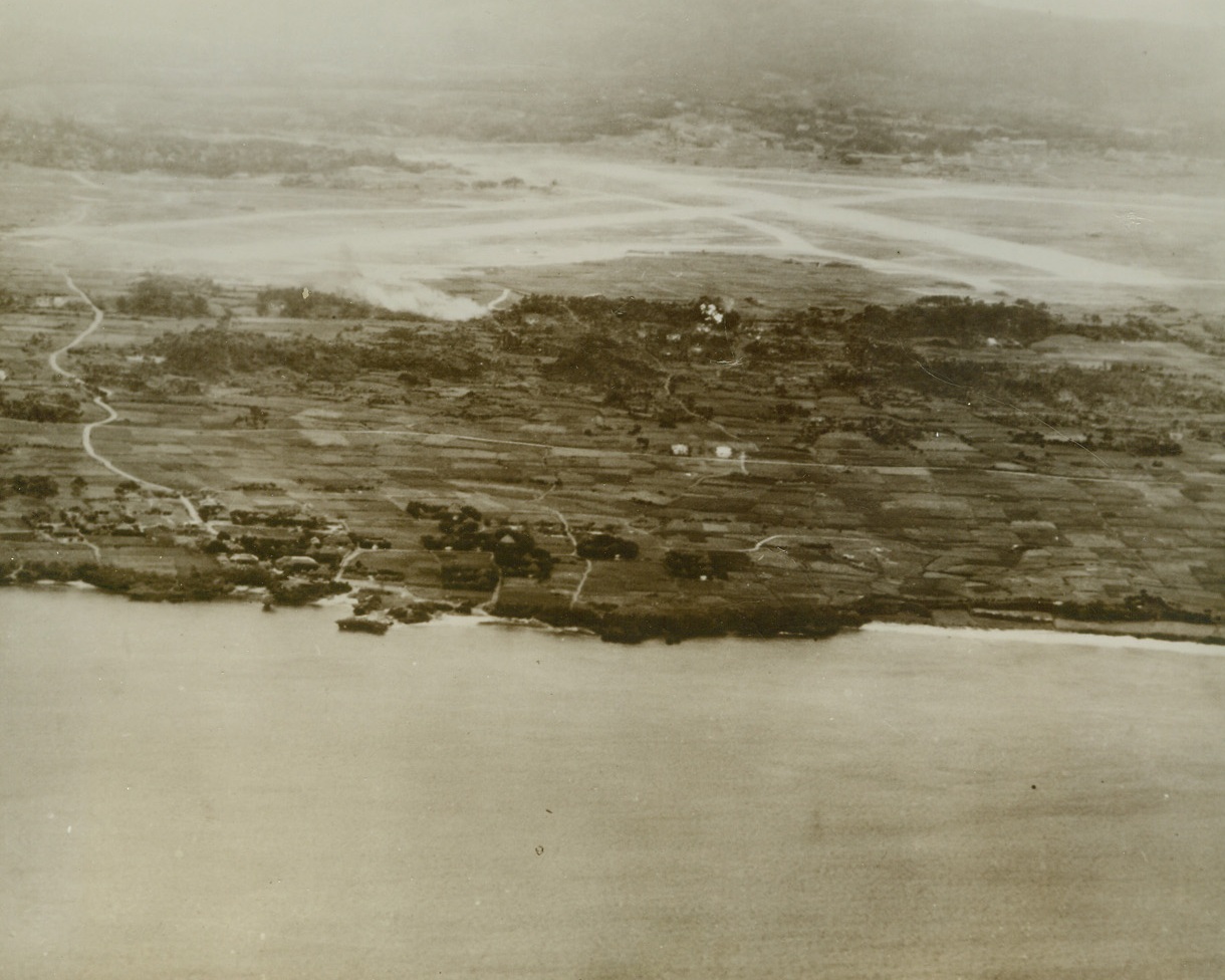 Taken by Yanks on Okinawa, 4/1/1945. Okinawa – Thirteen miles north of Naha, capital of Okinawa in the Ryukyu chain, is the Yontan Airdrome, taken by Marines and Infantrymen of the newly formed 10th Army after invasion of the island April 1st. Only a mile from the coast, it is on high ground with good drainage. The longest of its three coral strips runs from left to right in photo and is 5,100 feet in length. Marines took the airdrome only one hour after invasion.Credit: U.S. Navy photo from ACME;