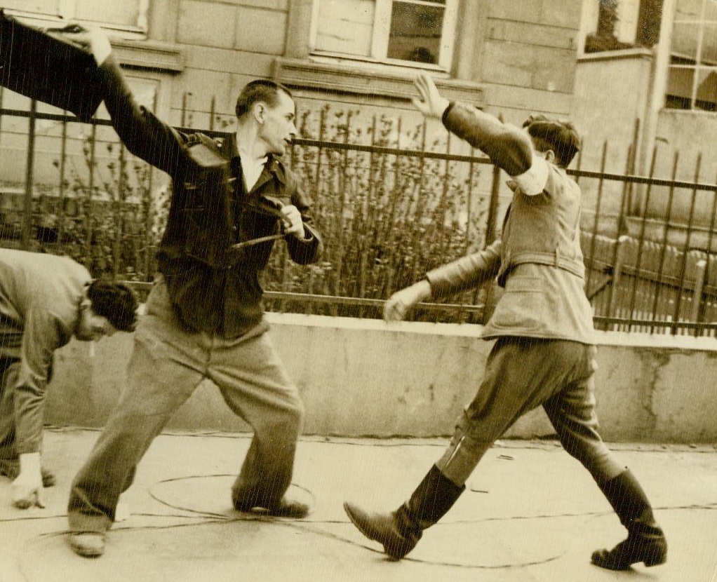 No Title. 4/3/1945. Bonn Germany – Liberated by the Allies and on their way to a “displaced persons center” in Bonn, former Russian slave laborers ran into a German civilian policeman – One of their erstwhile tormentors. It was a Russian victory all the way, as the freed man staged a lightning attack in the street. The battle ended with the enemy in full flight. Unleashing his pent fury and hatred, the Russian goes to work on the German policeman, who raises his arm to ward off the blows.;