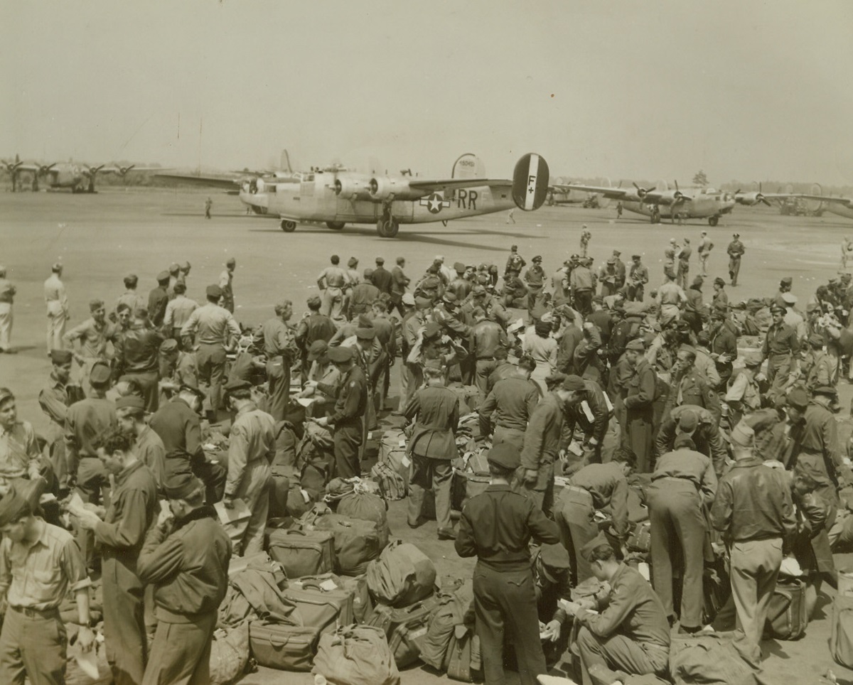 Bombers Fly Veterans Home from England, 5/22/1945. Connecticut -- The arrival of 50 battle bombers at airports between Springfield and Hartford today marked the first flight of a mass aerial ferry service from England to America, which is expected to return home more than 40,000 U.S. 8th Air Force personnel within the next 60 days. About 1,000 men were in the first contingent. The returnees will be given 45 days leave for “temporary duty, rest and recreation.” Here, at Bradley Field, some of the B-24 Liberators of the flight land. Men in the foreground have already landed in other ships. Credit: ACME;
