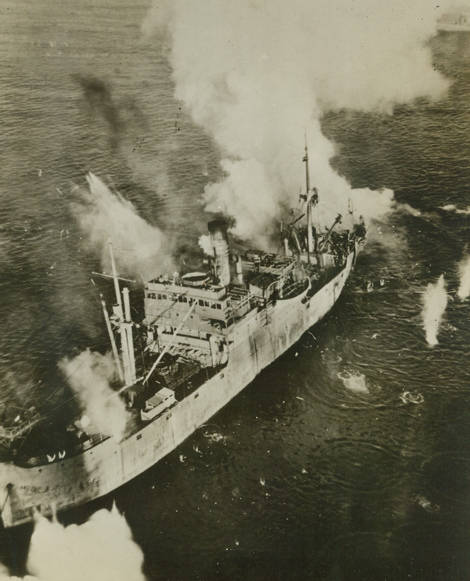 Surprise Attack Nets Six Jap Ships, 6/12/1945. Kurile Is. – Its stern blown away by a direct bomb hit from a Mitchell Bomber, this 2,500-ton Japanese cargo ship is dead in the water awaiting the attack from a second approaching Mitchell. The medium cargo was one of six enemy cargo and escort craft sunk or damaged by Aleutian-based Mitchells and Liberators in a surprise raid on a convoy at the Kataoka Naval Base, off Shimshu Is., in the Kuriles. Credit: Official U.S. AAF Photo from ACME;