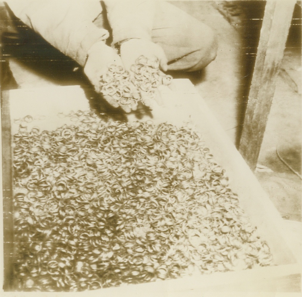 Buchenwald Wedding Rings, 8/5/1945. These thousands of wedding rings were found by U.S. 1st Army troops in a cave adjoining the Buchenwald concentration camp near Weimar, Germany. Signal Corps caption says they had been removed by Germans from their victims in order to salvage the gold. (AP Wirephoto from Signal Corps Radiophoto);