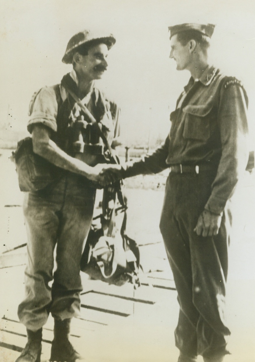 Mutual Exchange of “Good Luck”. The above photo flashed to the United States by Radiotelephoto shows at a Sicilian port, a British Commando officer and an American Ranger officer each wishing each other “good luck” prior to embarking for expanded operations which resulted in the capitulations of Italy. Credit: (ACME Photo via U.S. Army Signal Corps Radiotelephoto);