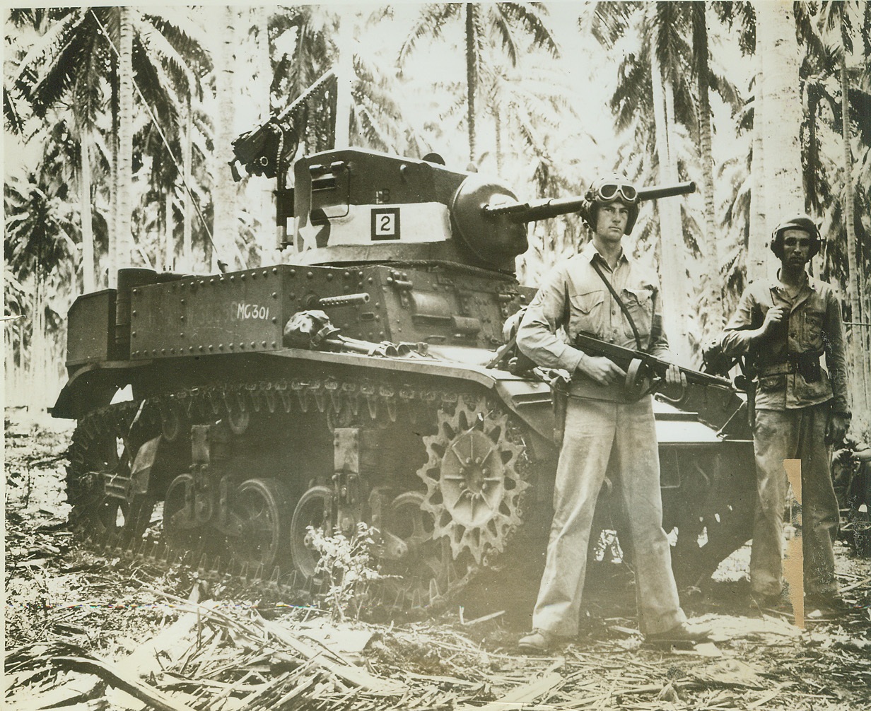 Jap "Mopper-Uppers". WASHINGTON, D.C. -- This photo, taken during the early fighting on Guadalcanal Island and released by the Marine Corps in Washington, today, shows two well-armed Marines standing next to their "Mopper Upper" light tank, with which they cleaned out pockets of Jap resistance in the fight at Tenaru River.  Credit: (U.S. Marine Corps Photo from ACME);