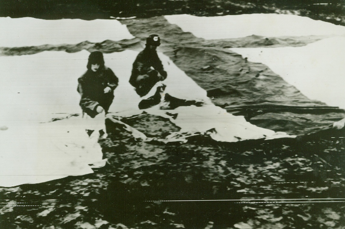 No Title. Near Nettuno, Italy. German bombing of American evacuation hospital. Red Cross flag sprawled out just behind bomb crater on hospital grounds was torn by anti-personnel bomb dropped by Germans. Over 100 casualties. L-R Nurse Lt. Sally Hocutt Wendell, N.C.; and Pvt. Marshall Floyd of Marshville, N.C.;