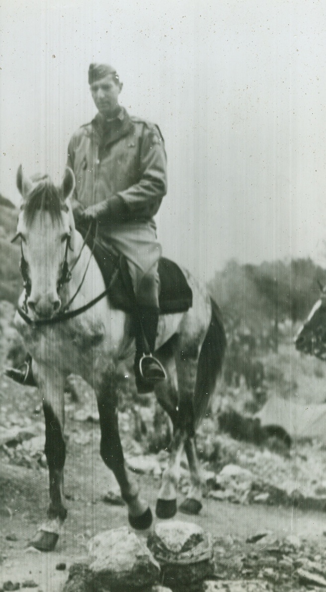 No Title. Lt Gen Mark W. Clark, Commander of the 5th Army in Italy, inspects area of French Mountain Division of 5th Army in rugged terrain across Garigliano River. Photo by Sherman Montrose, Acme photographer for the War Picture Pool.;