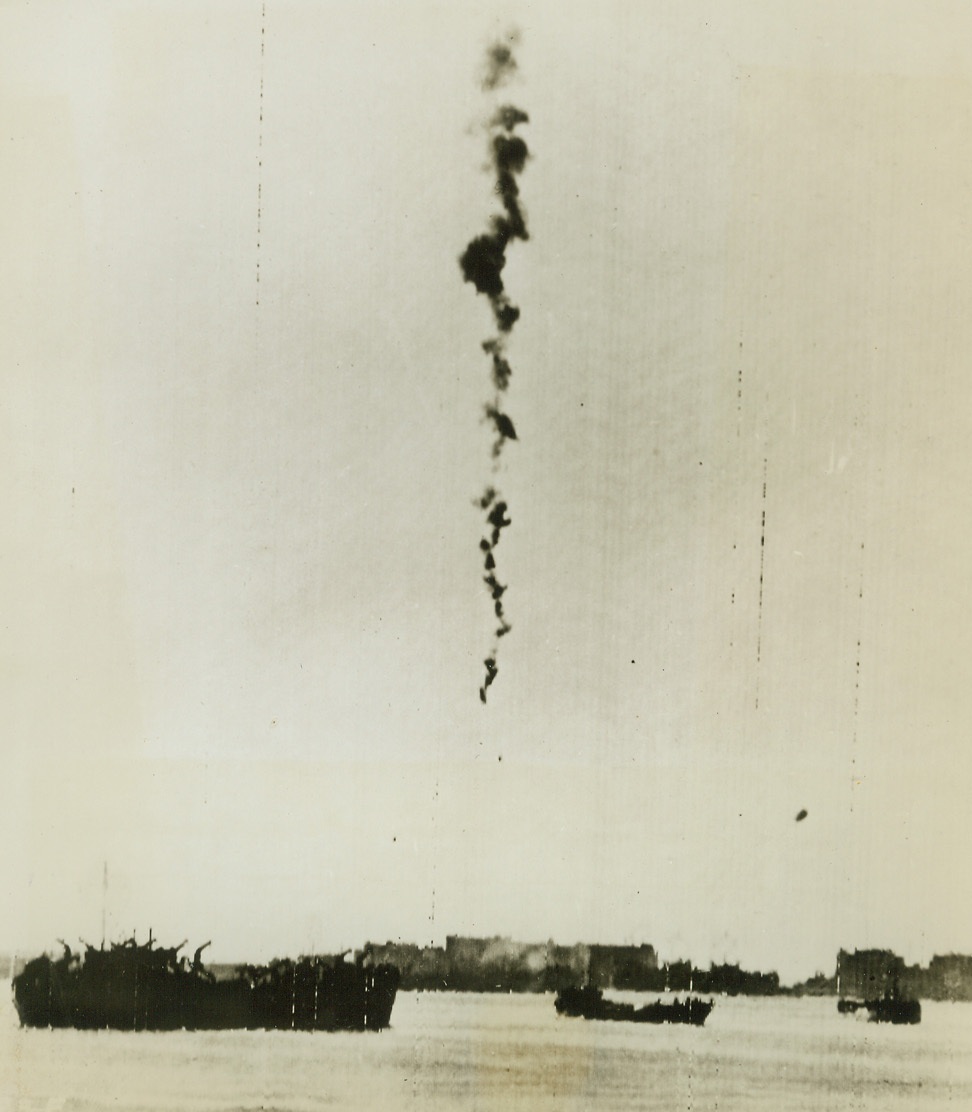 One More Downed. WASHINGTON, D.C. – A German dive bomber plummets into Anzio Harbor leaving a trail of smoke, after being hit by ack-ack. The plane fell among the Allied ships lying at anchor in the harbor. Credit (Acme Photo by Bert Brandt for War Picture Pool via Army Radiotelephoto);