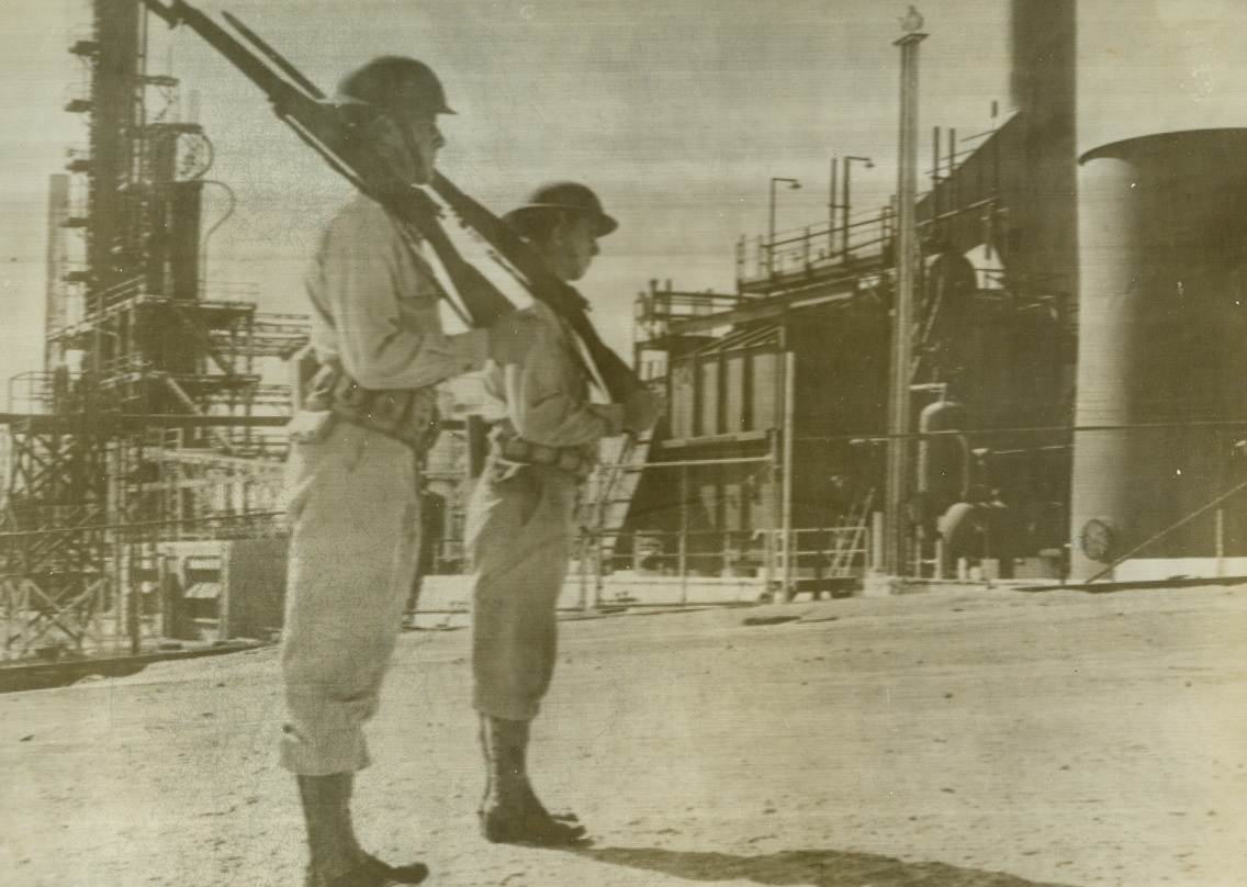 Two American soldiers guard Lago oil refineries on Dutch island of Aruba West Indies where German sub once shelled installations. American and Dutch troops now diligently protect Dutch possessions in Western Hemisphere..