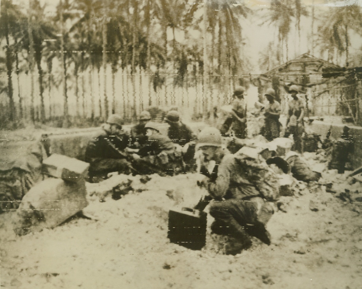 Yanks Take Cover. Southwest Pacific – In the remains of a cocoanut shed, United States troops, now engaged in pressing back the Japs, take cover “somewhere in the Southwest Pacific.” Credit line (U.S. Army radio telephoto from ACME);