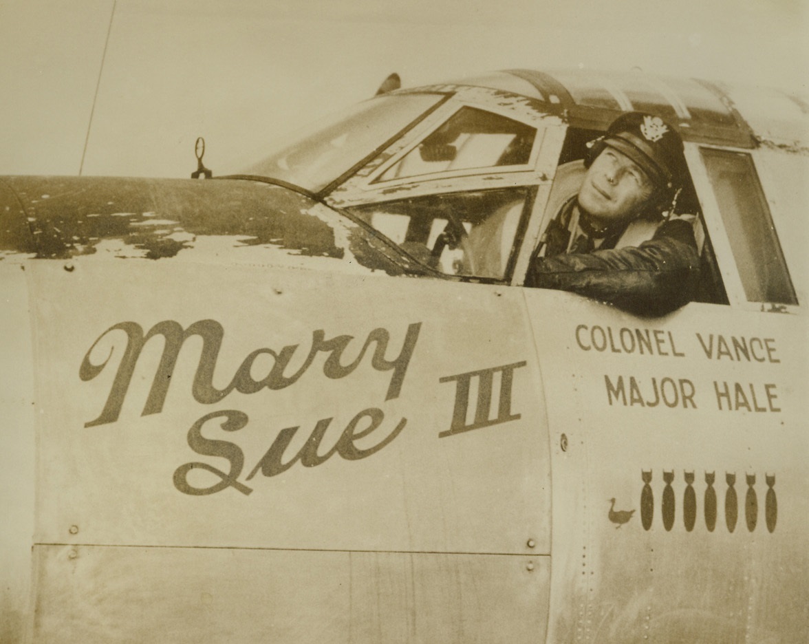 Texan Leads Bomber Group. Col. Reginald F. C. Vance, London-born commander of the U.S. 9th Air Force “Silver Streak” Marauder Bomber Group, looks out from the cockpit of one of the unpainted bombers at a base in England. Col. Vance’s group was the first to shed the olive drab paint, thus making the plane faster by about 10 miles per hour. His present home is on San Antonio, Texas.;