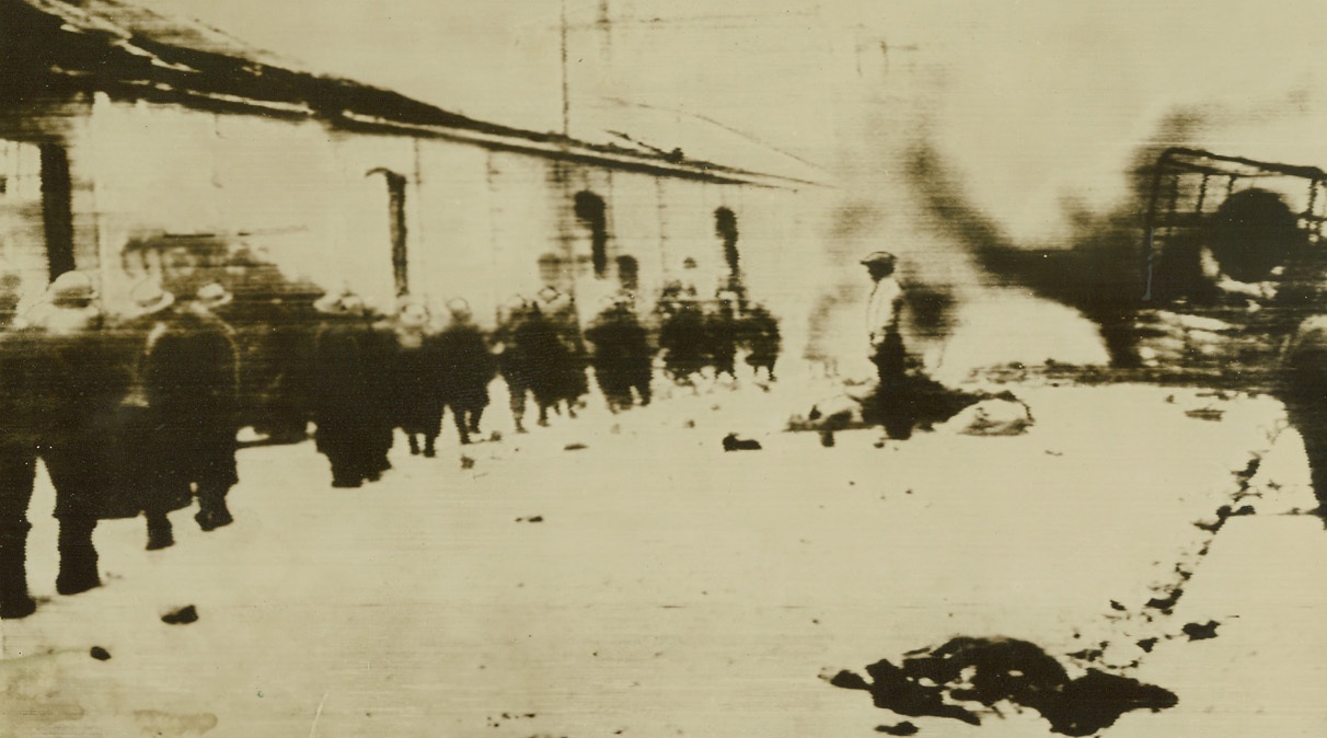 No Title. Last of the B.E.F. passing wreckage in street of Dunkirk on way to embarkation. (Radio, Paris-New York. Passed by Censors);