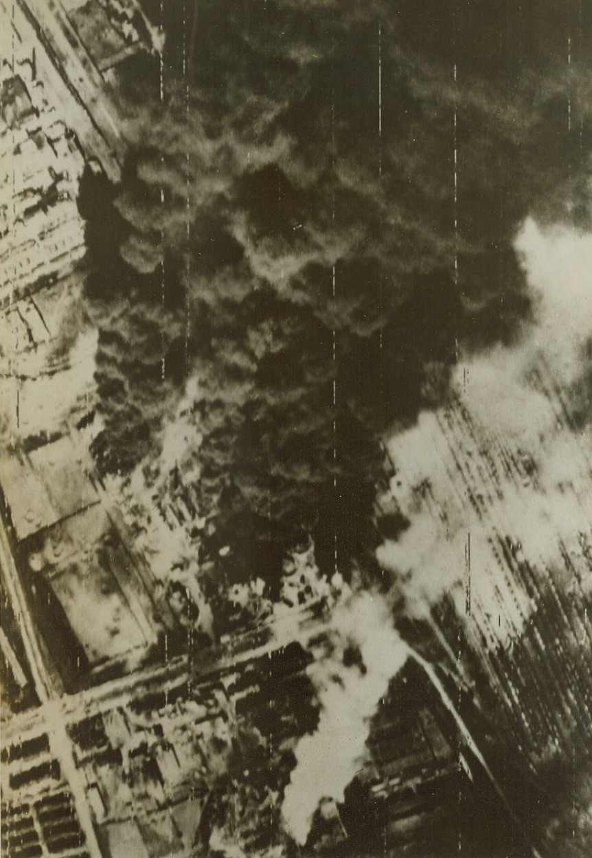 Budapest Bombed. England – Burning oil refinery and hits on crowded railroad yard indicate the successful first attack made by British and American MAAF when they struck April 3rd. Credit: U.S. Army Radiophoto from ACME;