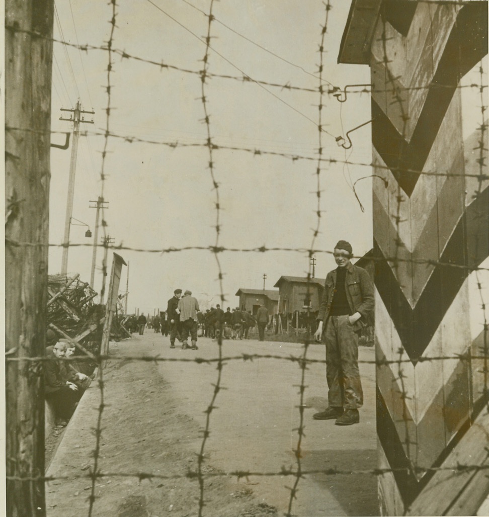 Nazi Prison Camp. GERMANY – This is the Russenlager section of Stalag XXIIA, Nazi prison camp now in Allied hands. Liberated prisoners wander aimlessly over grounds not quite able to comprehend newly-won freedom. Thick crossed barbed wire fences surround the area;