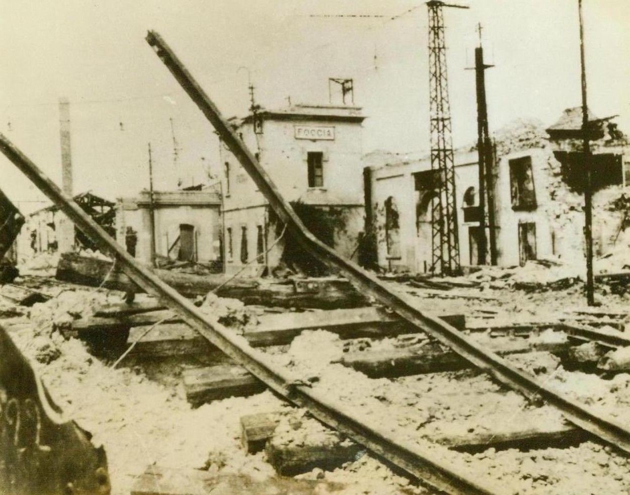 BLASTED RAILWAY YARDS AT FOGGIA. (Torn Caption) This photo flashed to New York by Radio… shows twisted rails and wreckage in … yard at Foggia, Italy, after it … by the Allies. When the city … the Germans it was a frequent … Today, British 8th … To have made a … Along the … Taken by A;