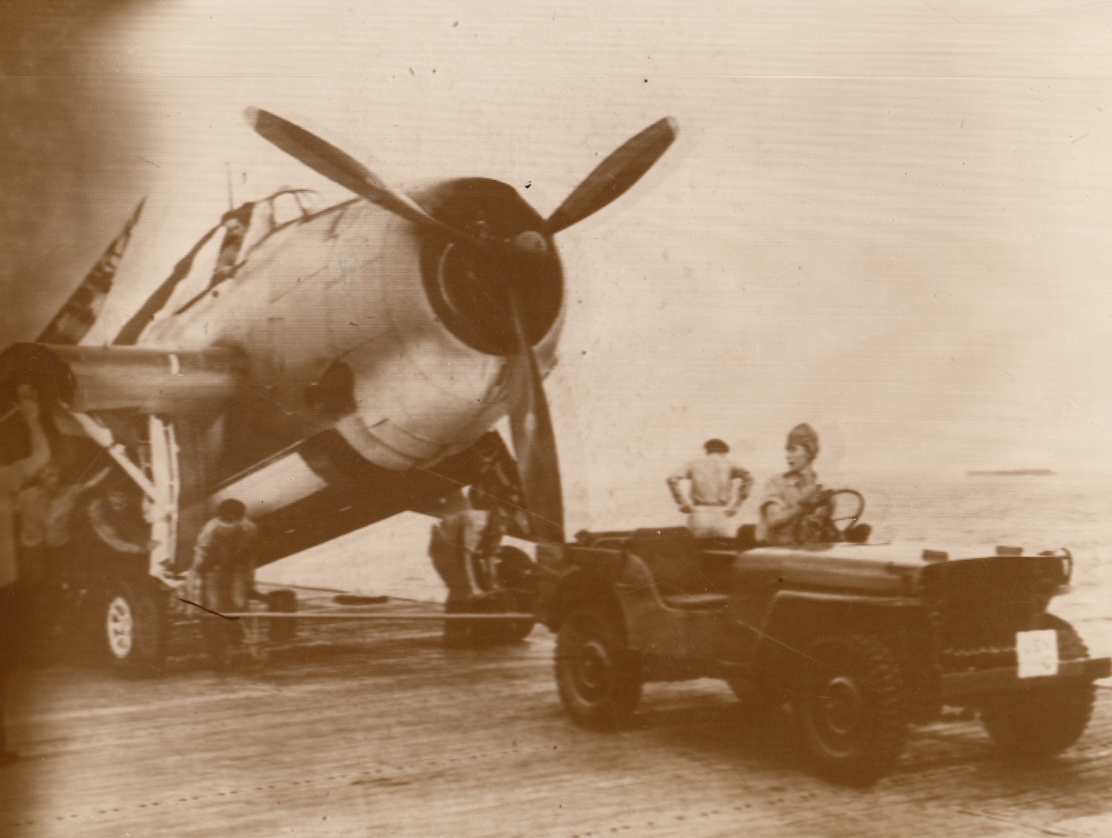No Title. The American Jeep really gets around. Here’s one aboard an unnamed aircraft carrier pulling a torpedo bomber into position to take off on the Navy attack on Jap-held  Wake Island.;