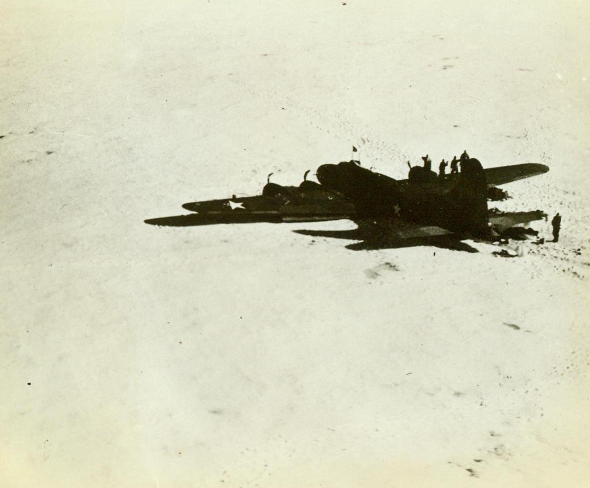 Arctic Explorer Directs Army Plane Rescue. Greenland – Navy flyers rescue an Army plane crew in a daring take-off from a Greenland ica-cap. Lieut. Col. Bernt Balchen of the U.S. Army, the famous Artic explorer directed the rescue of this B-17s crew after it was forced down on an icy plateau in Greenland when the gas supply ran out. This photo was made from the Navy plane that made the rescue, showing the flying fortress after it belly-landed in the snow, its landing gears retracted.  (ACME);