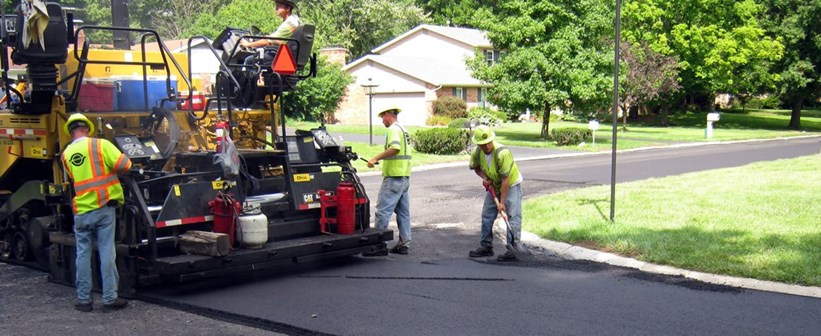 This is a picture of a crew resurfacing a city street.