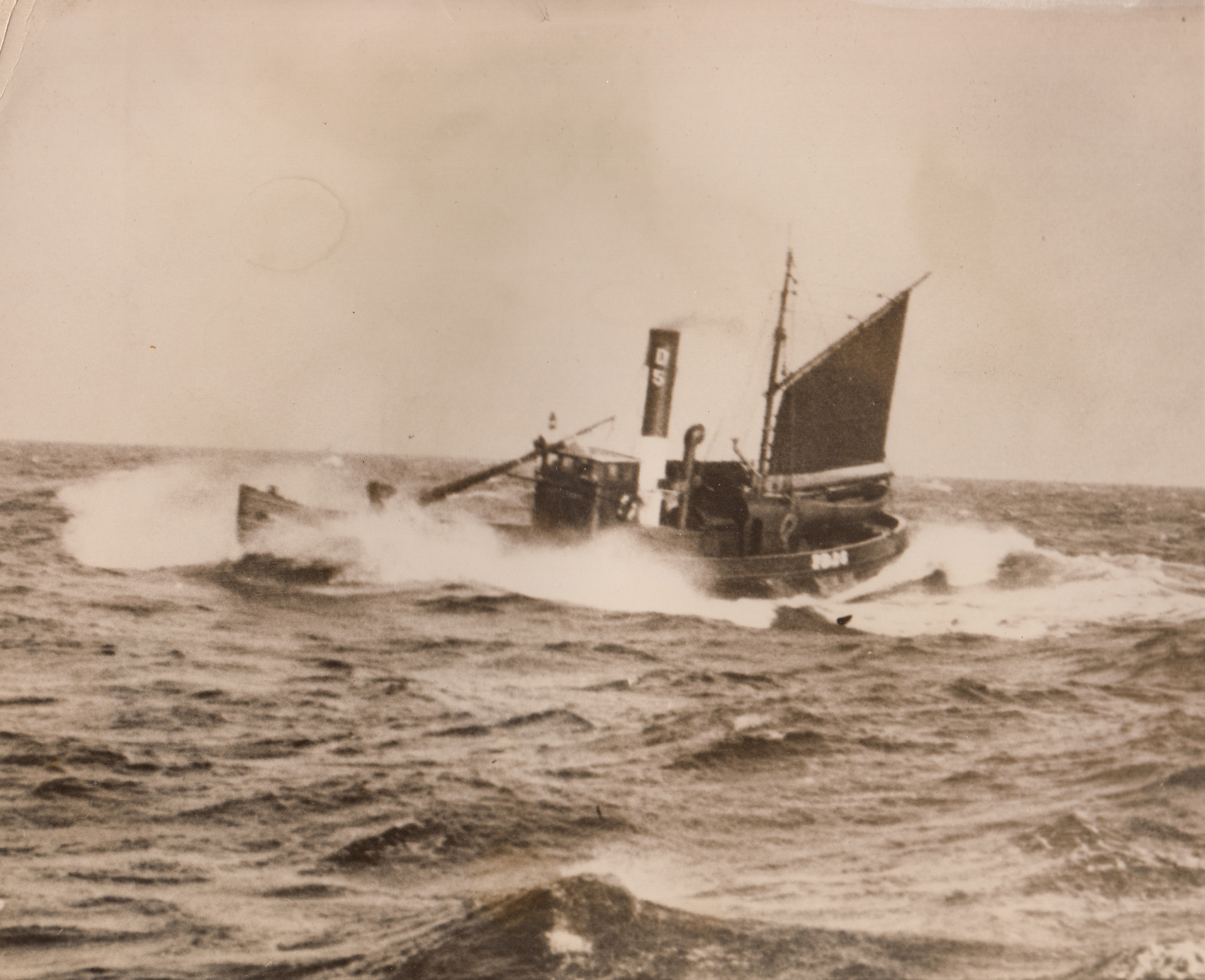 Feeding the “Tight Little Isle”, 2/9/1940  England – Depending largely on sea borne commerce to provide for her insular population, Britain, one referred to as the “Tight Little Isle” by Napoleon, looks to her fishing industry to provide a goodly percentage of the nation’s food, especially in times of war. Here is a fishing trawler, unit of Britain’s “Food Fleet”, shoving her bow into heaving seas as a sail augments the engines.;