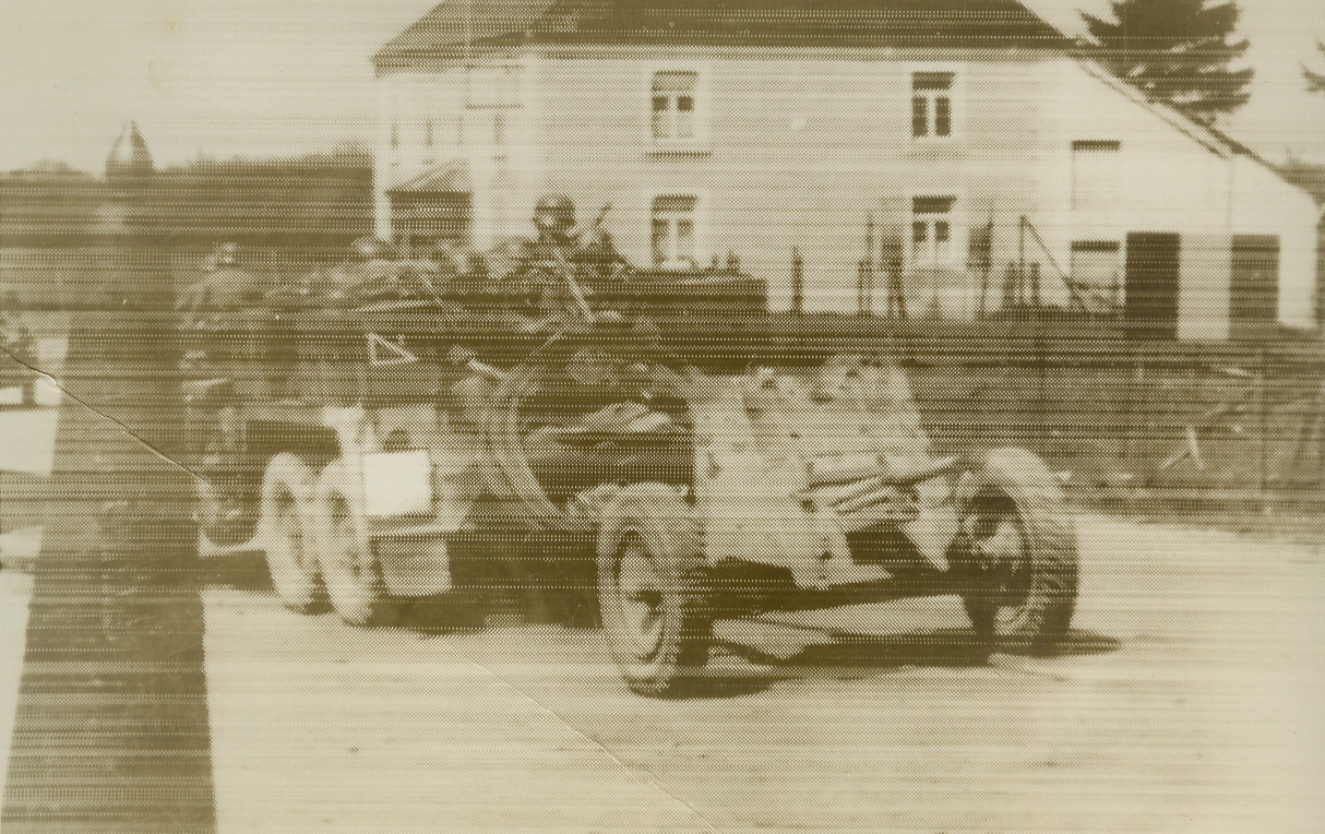 Nazi War Machine Rolls into Belgium, 5/11/1940  LUXEMBOURG-BELGIAN BORDER – A mechanized unit of the German army shown on Belgian soil, just after rolling past a post (left) marking the Luxembourg-Belgian border, at the outset of the swift Nazi invasion of the low countries. Steel-helmeted troops may be seen riding in the huge lorry, which is towing a light field piece. Photo radioed from Berlin to New York, May 11.Credit: (ACME Radiophoto);