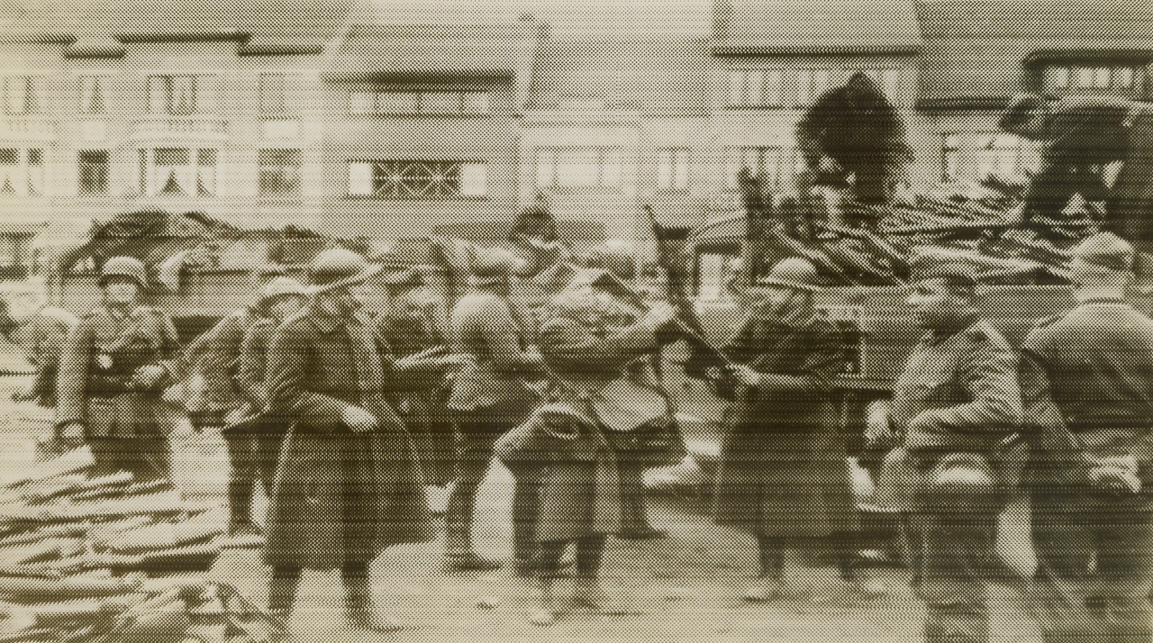 BELGIAN SOLDIERS HAND OVER THEIR ARMS, 6/3/1940  BELGIUM—Nazi censor says this radiophoto shows Belgian loading their rifles on a truck after Kin g Leopold’s recent surrender of his army to Germany. The surrendered warriors are apparently doing the work, and Nazi troops may be seen closely watching the loading. Photo flashed to New York from Berlin, June 2. Credit: Acme Radiophoto;