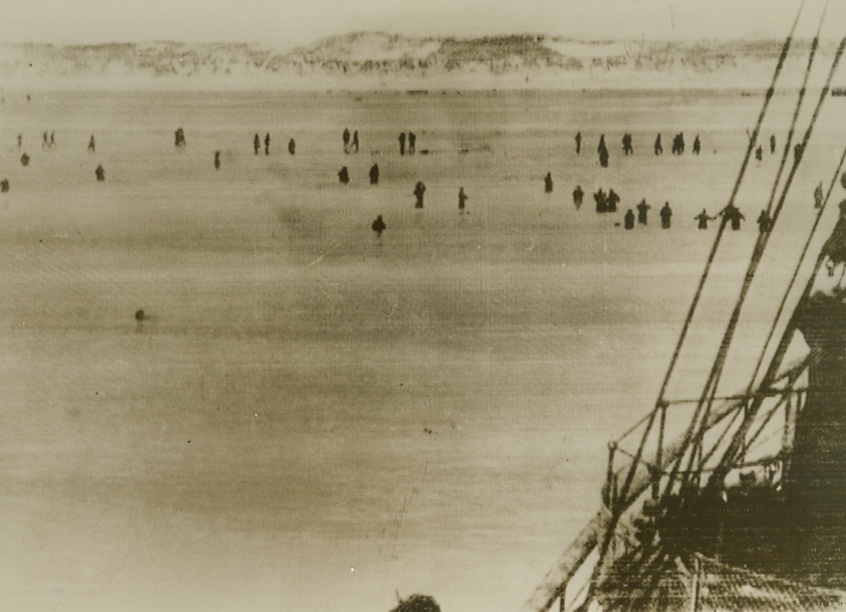 ALLIED TROOPS EVACUATING DUNKERQUE WADE TO RESCUE SHIPS, 6/4/1940  DUNKERQUE, FRANCE—Allied troops are shown wading out from the sandy beaches of Dunkerque to ships of the rescue fleet in this picture flashed to New York from London by cable, June 4th. Part of one of the rescue ships can be seen in the right foreground. The evacuation of the Allied “Lost Army” from Dunkerque was reported completed as the German high command claimed the capture of the port.  Credit Line (ACME Cablephoto);