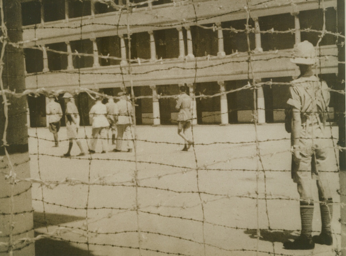 Italians in British Prison Camp, 7/11/1940  Egypt—Italian officers, among the first prisoners taken in fighting on the Eastern front, walking inside the barbed-wire enclosure of a British prison camp in Egypt.Credit: ACME.;