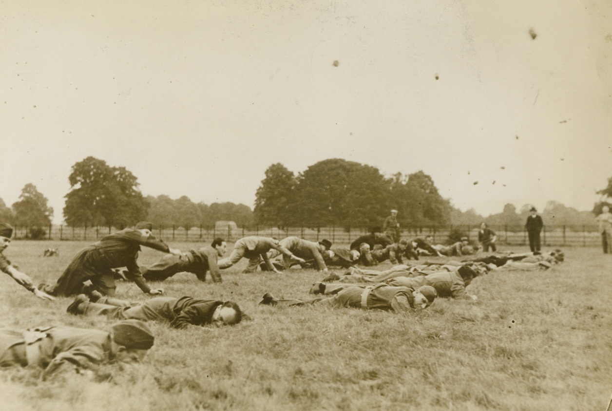 Britain’s Home Guard Studies Guerrilla Warfare, 8/7/1940  Middlesex, England - Members of Britain’s ever-increasing Home Guard who desire instruction in guerrilla warfare tactics are attending a privately run school at Osterley Park. The courses are designed to show how to meet new situations and how to use guile in overcoming the enemy. All instructors are experienced veterans. Here, Home Guards, some of them still in civilian clothing, practice hand grenade throwing from prone positions. The air is filled with missiles used in practice. Credit: ACME;