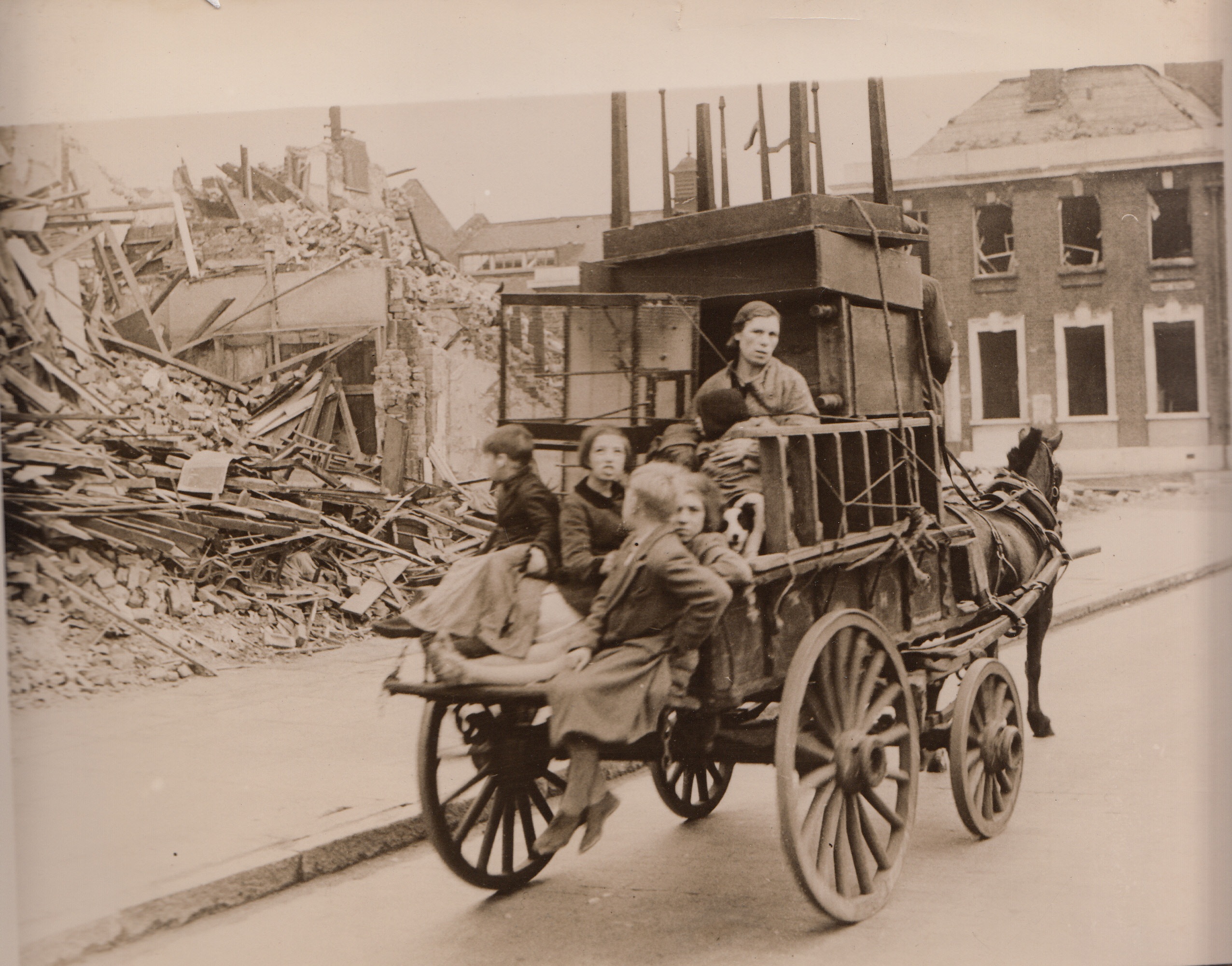 Out of the East End, 10/1/1940  LONDON - A woman and children bombed out of their homes in London's East End drive past ruined buildings on a cart piled high with household belongings as they search for new shelter. Even the cage of birds was taken along.;