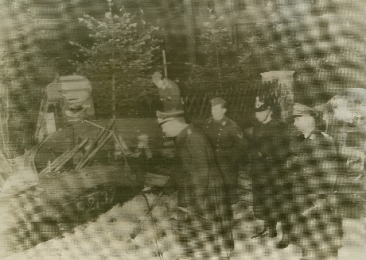 BRITISH BOMBER DOWNED IN BERLIN, 10/20/1940  BERLIN, GERMANY—German officers inspect the wreckage of the first British plane to be shot in the streets of Berlin proper, during action Oct. 20. The Nazis, charging that the British rading [sic] bombers had syruct [sic] two hospitals, threatened a “thousand-fold” revenge on England.Credit: Acme;