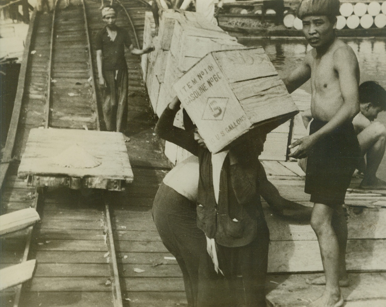 U.S. Gasoline for Lamps of Indo China, 10/27/1940  Haiphong, Indo China – Natives carry 10-gallon crates of American gasoline from the docks of Haiphong into shore. The gasoline, which belongs to Standard Oil, is part of huge U.S. holdings in Indo China now endangered by the Japan-Vichey Pact. Credit: ACME;