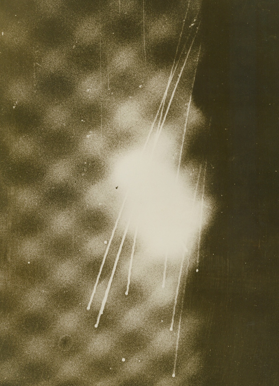 London’s Spectacular Night, 12/5/1940  London - One of the most unusual pictures made of London’s night-time battle against invading German bombers, this photo shows England’s defense against a new menace - parachute flares to offset moonless nights and the blackout. Flares are seen in the center, with tracer bullets fired by anti-aircraft units in an attempt to put them out cutting streaks of brilliant light through the already-bright glare above the city. Credit: ACME;