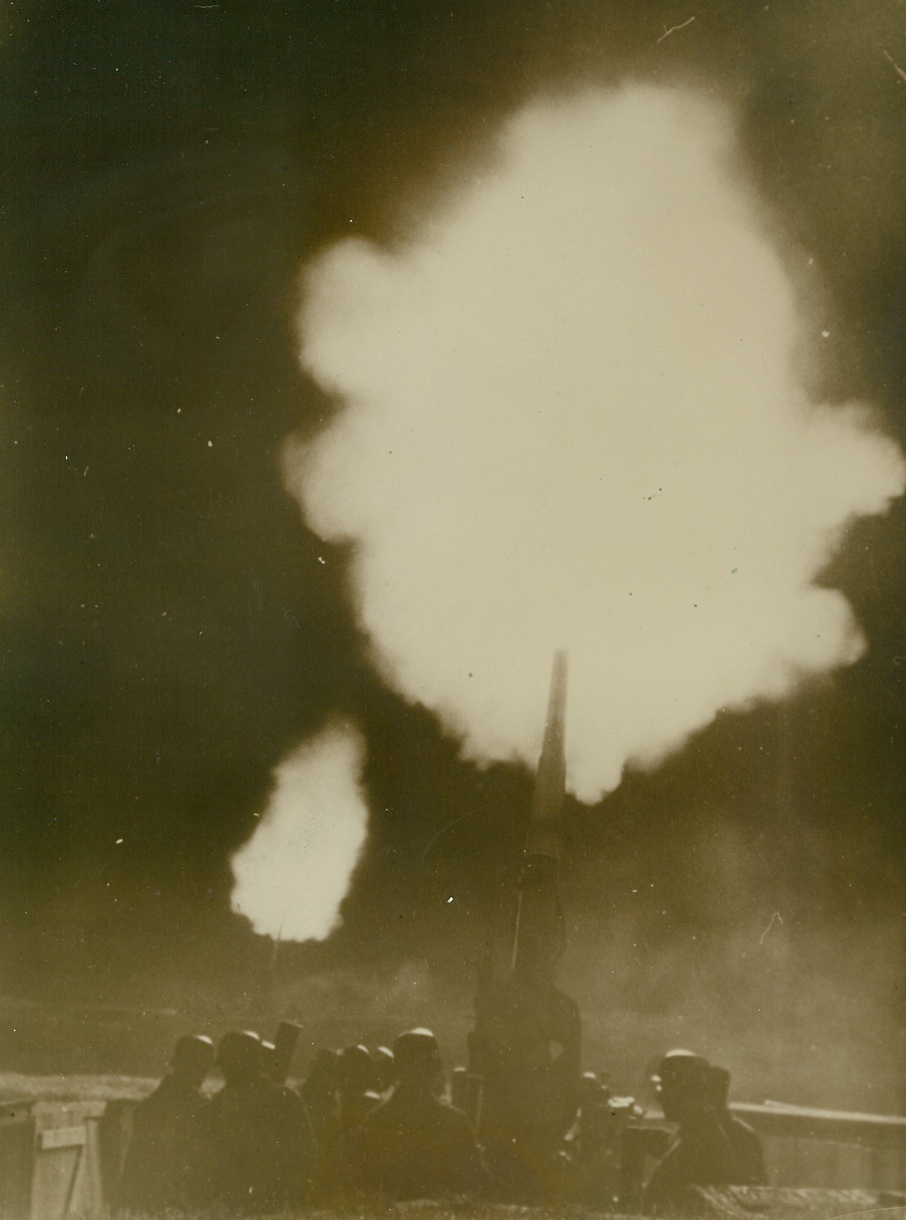 IN DEFENSE OF GERMANY, 12/17/1940  GERMANY—A heavy German “flak,” or anti-aircraft gun, in the foreground and another in the distance belch forth clouds of smoke and flame as they go into action against British planes over Germany. Credit: Acme;