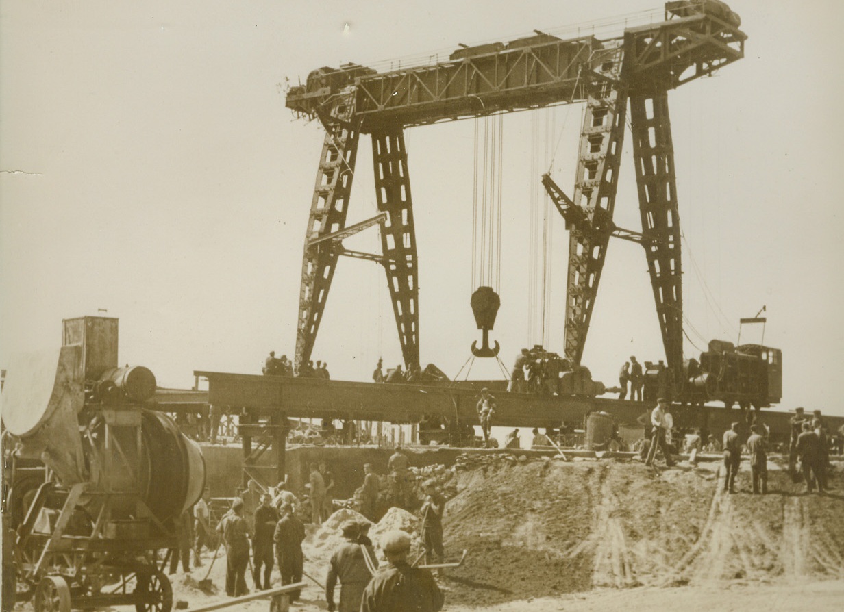 GERMANS BUILDING CHANNEL FORTIFICATIONS, 12/25/1940  A giant crane, hoisting steel girders into position as supports for one of the huge gun emplacements built by the Germans along the Channel coast facing England. Yesterday, (Dec. 24), Nazi officials boasted that their line of fortifications extended for 620 miles along the channel.  Credit Line (ACME);