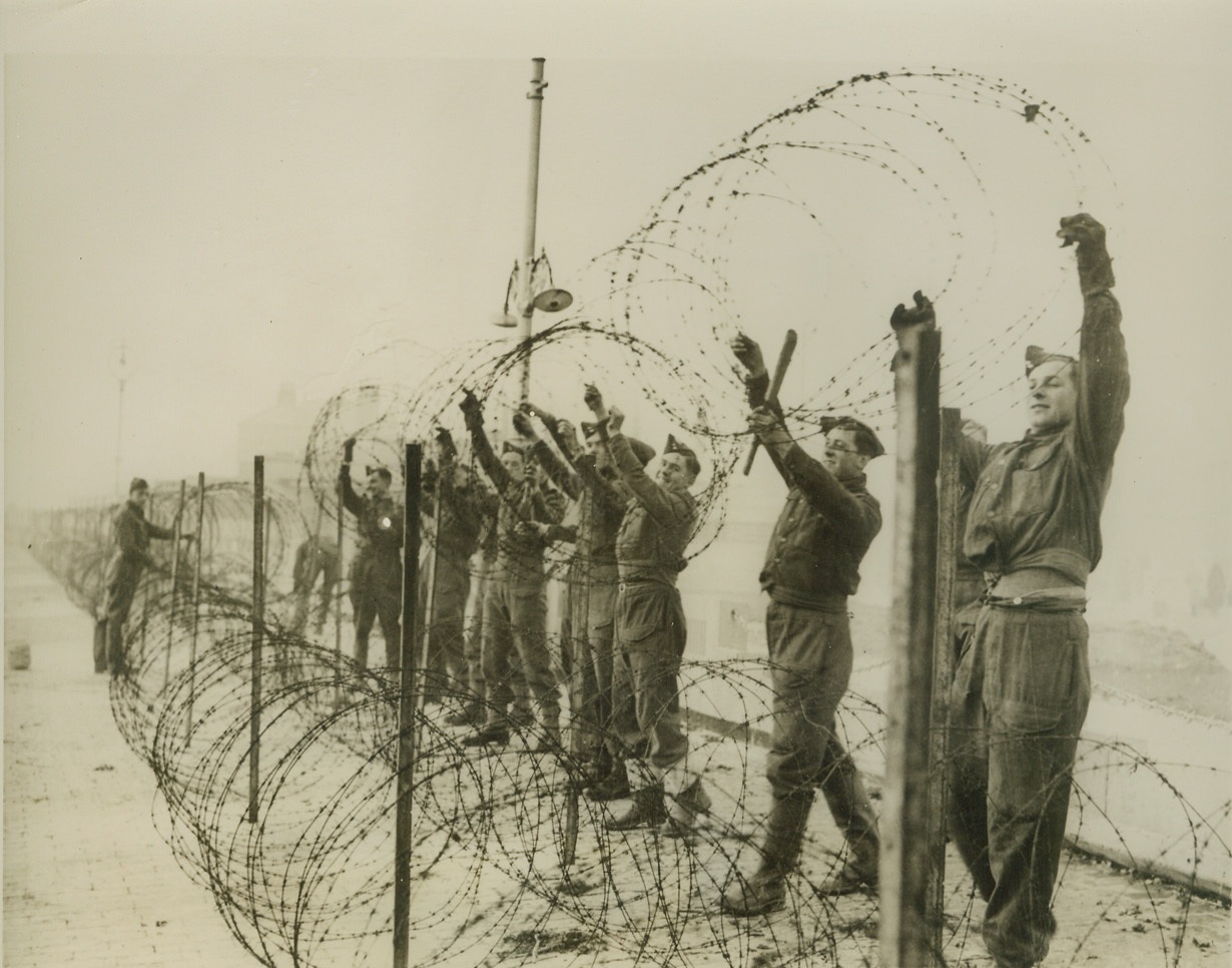 More Anti-Invasion Snares, 12/26/1940  ENGLAND -- As new fears of a German invasion attempt on England, these Tommies strung more barbed wire to strengthen defenses along the English south coast. Credit: (ACME);