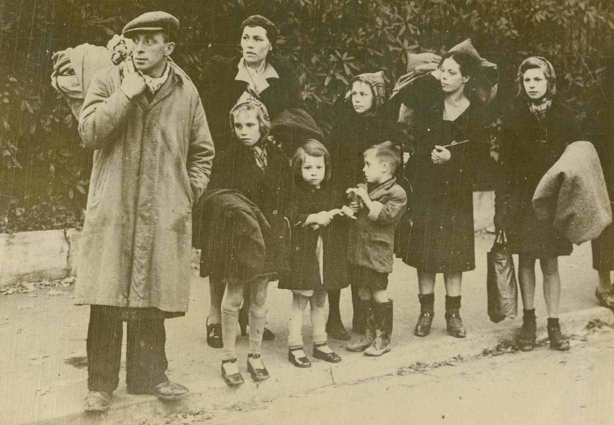 Refugee, English Style, 12/26/1940  Southampton, England – To the long lines of refugees from Hitler-conquered countries are added now English civilians driven from their homes by bombs and forced to seek shelter in other more fortunate towns. These residents of Southampton, their homes destroyed, are waiting on the city limits for a passing car or truck to carry them away to more peaceful areas. Passed by British Censor. Credit: ACME;