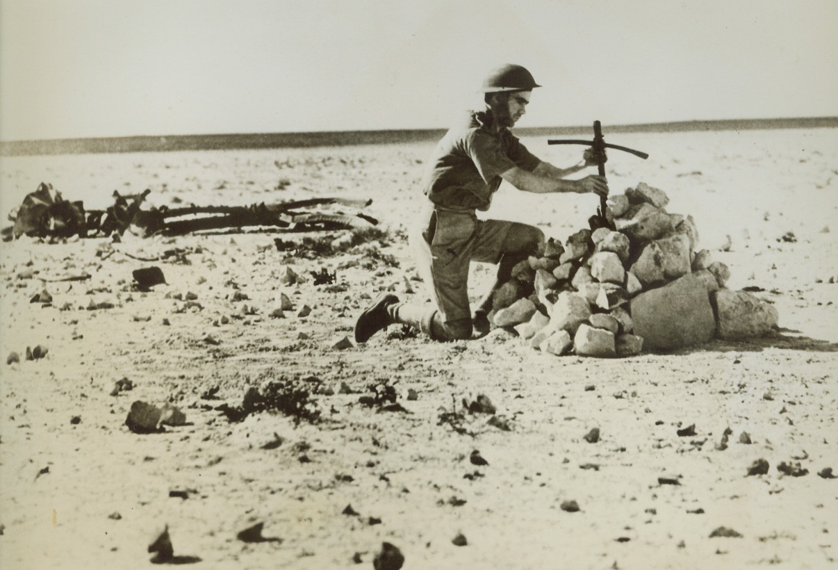 A Last Courtesy, 12/27/1940  Mersa Matruh, Egypt – An R.A.F. airman places a cross made from the wreckage of their S.79 plane over the grave of five Italian airmen shot down in battle over the desert Oct. 31.  Eight Italian aircraft were shot down in flames, four were seriously damaged, and only one of the 35 airmen flying the twelve planes escaped death. Credit line (ACME);
