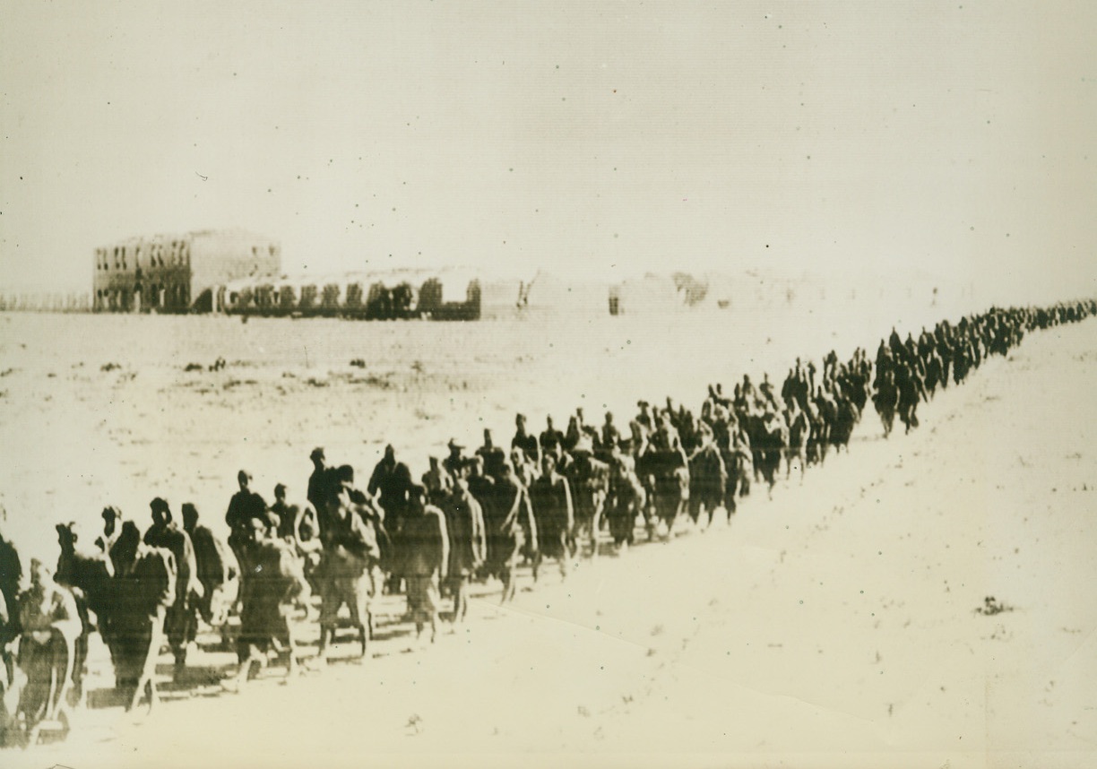 Captured Italians Leave Sidi Barrani, 12/29/1940  SIDI BARRANI, EGYPT – The ruins of their base in the background, some of the more than 10,000 Italians captured by the British at Sidi Barrini march away to spend the remainder of the war in a desert prison camp.  Farthest point of Italian penetration into Egypt, the base was retaken by the British Dec. 11 after a heavy bombardment from land, air, and sea.Credit: (ACME CABLEPHOTO);