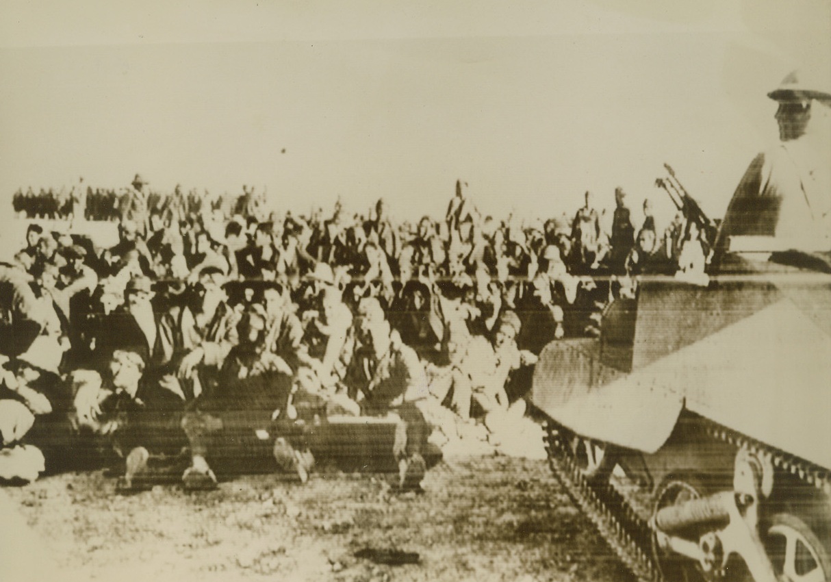 Captured Italians Await Internment, 12/29/1940  Cairo, Egypt - - Guarded by a light tank crew, scores of Italians taken prisoner by the British in the capture of Sidi Barrani sit disconsolately awaiting transportation to a prison camp where they will remain for the duration.  It was reported that 30,000 prisoners were taken after a land, sea and air bombardment had subdued Italian forces occupying the desert base.  Passed by British censors, this is the first photo received in this country from North Africa since the start of the English counter-offensive. Credit line (ACME Cable photo);