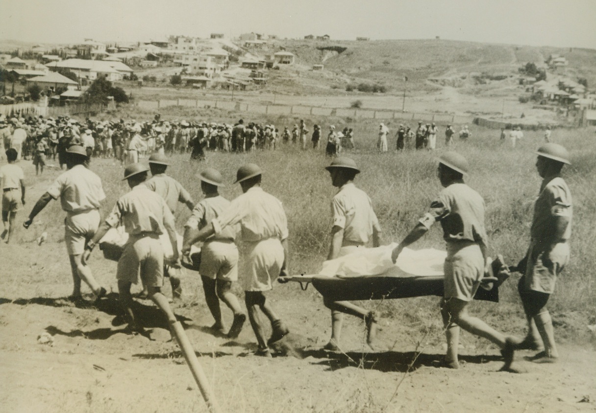 Tel Aviv Buries Air Raid Dead, 12/31/1940 Tel Aviv, Palestine.. – Members of the Tel Aviv Civil Guards carry the bodies of those killed during the Italian raid on the city to the cemetery here.  These photos, made some time ago are the first pictures reaching here following the disastrous bombardment of the Palestine capital. Credit line (ACME);