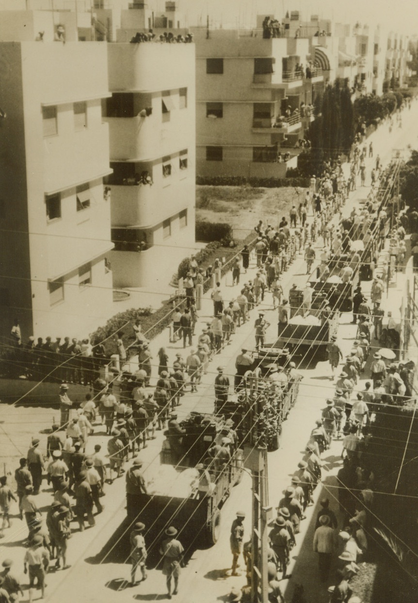 Tel Aviv Buries Air Raid Dead, 12/31/1940  Tel Aviv, Palestine - - Trucks carry the bodies of the victims of the Italian raid on this city through the streets to the cemetery where all were buried in a common grave.  A number were killed in the raid.  This is one of the first photos arriving here since the raid, which occurred some time ago. Credit line (ACME);