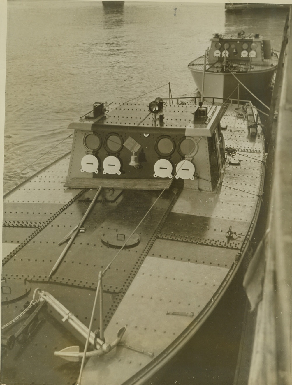 TARGETS FOR DIVE BOMBERS, 1/5/41  ST. LOUIS, MO. – Armored gasoline powered target boats tied up in St. Louis, enroute from Great Lakes Training Station to join naval units in Gulf of Mexico. Black stripe down center of boats are bulls eyes for dive bombers which use the boats as live targets during practice. Although planes use Non penetrating bombs operators of targets have feeling of mouse waiting for cat to pounce. Credit: OWI Radiophoto from ACME;