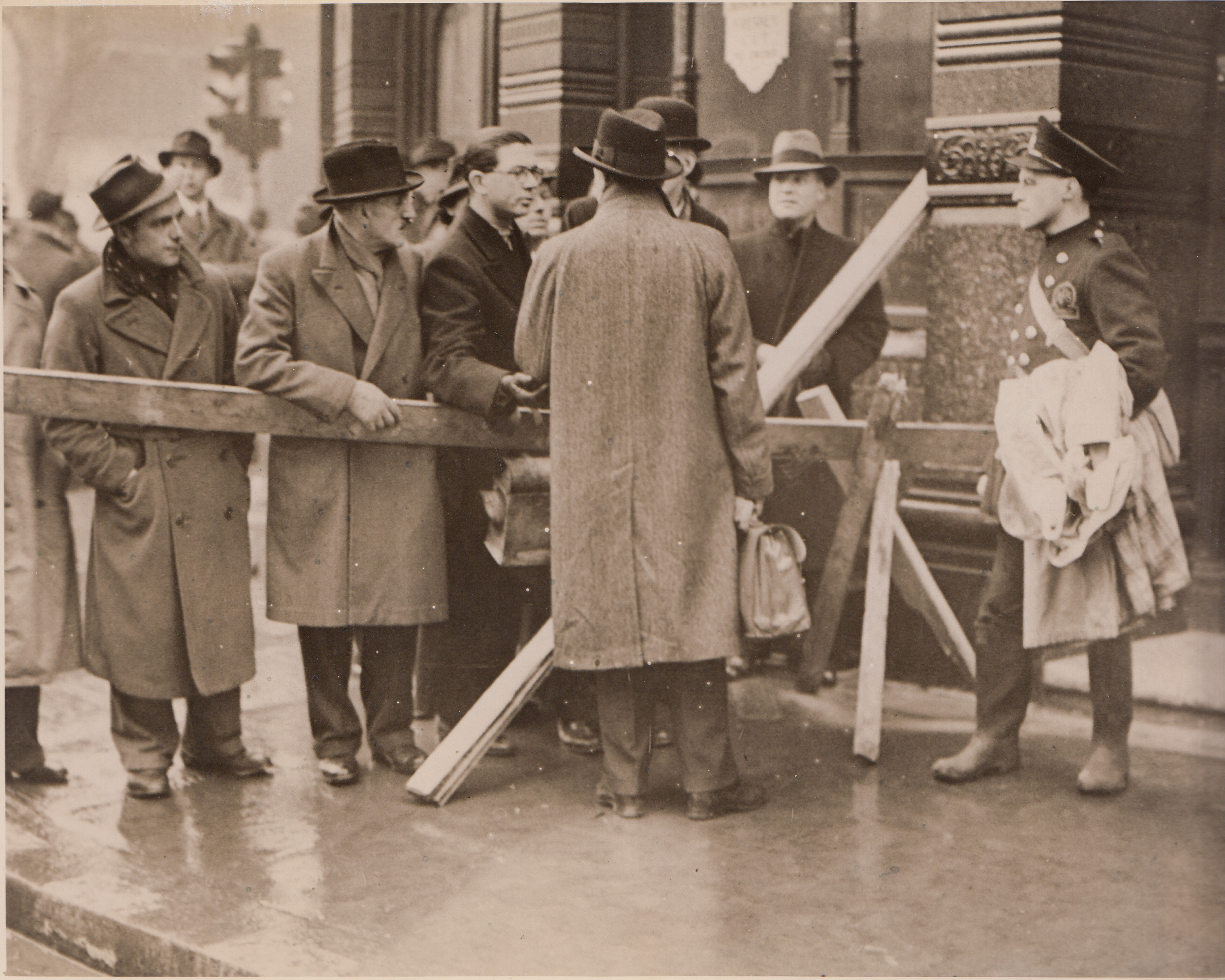 London Carries On, 1/14/41  LONDON - Following the most destructive air raid ever felt by the city, Londoners line up at this barrier to ask officials if their office building is still standing.;