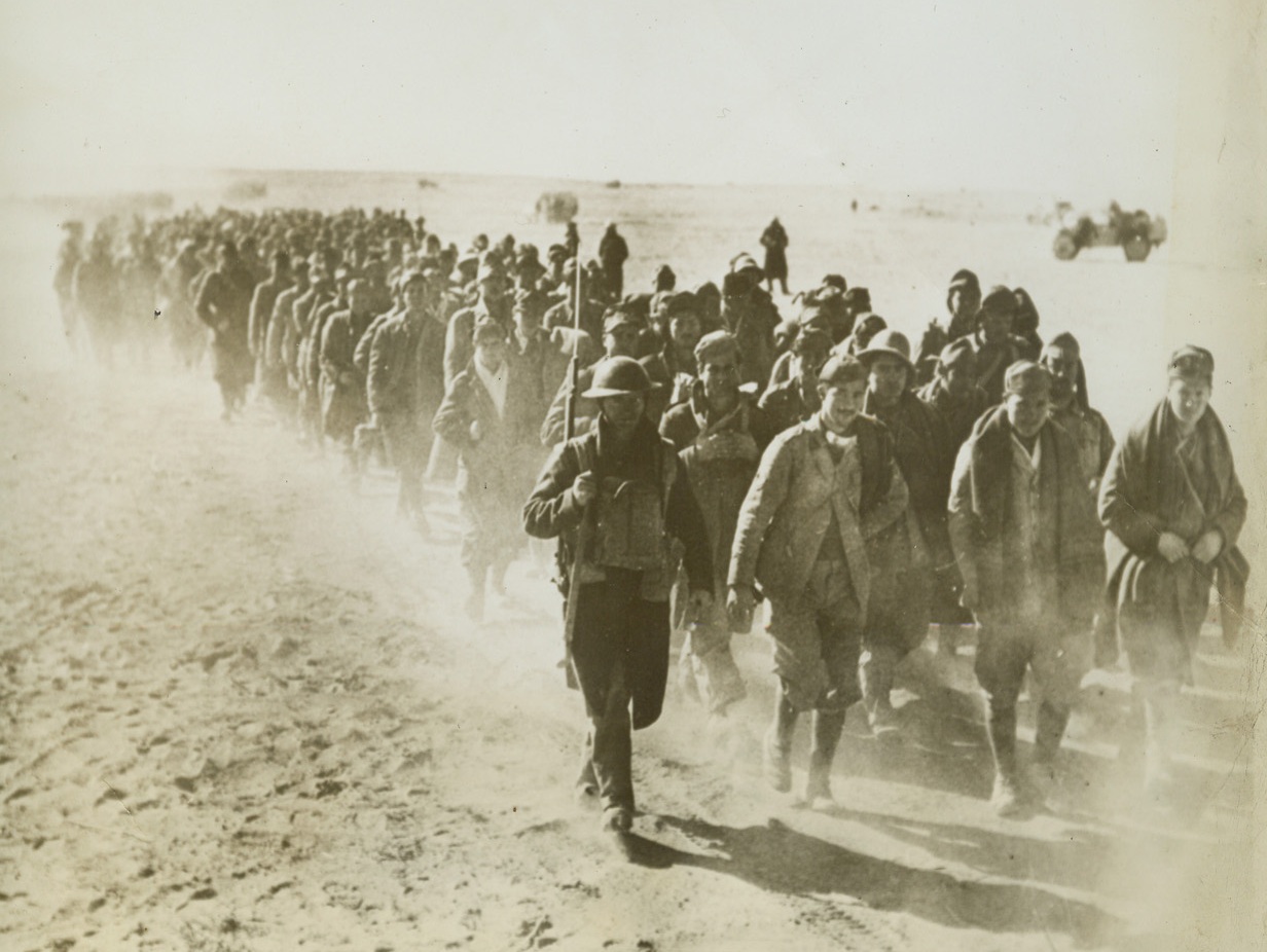 Italian Prisoners Taken in Libyan Drive, 1/14/41  Libya—Guarded by a lone British soldier with a bayoneted rifle, several hundred Italian prisoners taken by the British forces in their drive against Sidi Baranni and Bardia raise clouds of dust as they march to the rear and waiting concentration camps.Passed by British censor—via clipper.Credit: ACME;