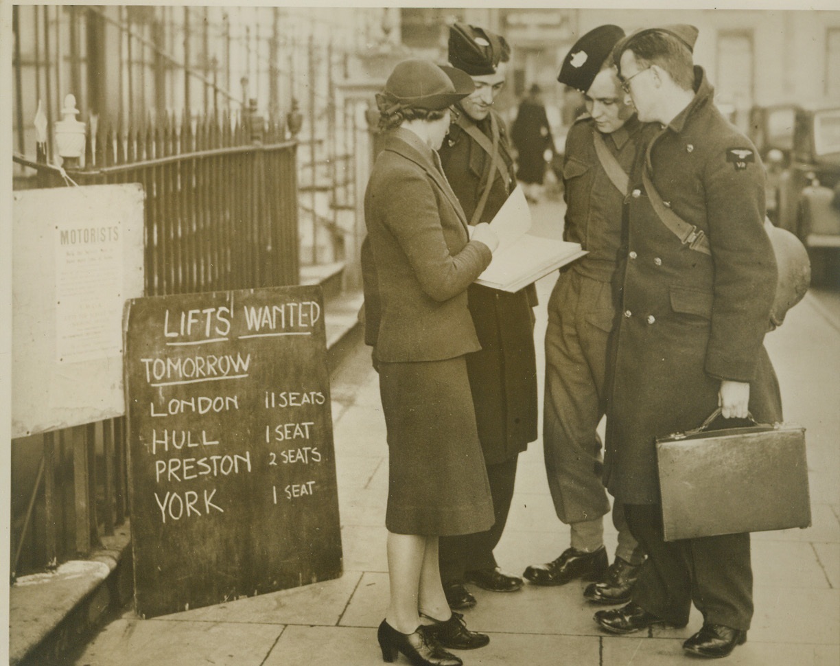Lifts for Tommies on Leave, 1/25/41  LONDON -- A London Y.M.C.A. has enlisted the help of motorists to give rides to British soldiers on leave, thus shortening the hours of travel for the Tommies. A booking office has been established, where men on leave can register their destination and day of travel. Appeals to motorists are made in theaters and by means of posters. This Y.M.C.A. worker is seen checking out three soldiers who have found motorists to take them home. Credit: (ACME);