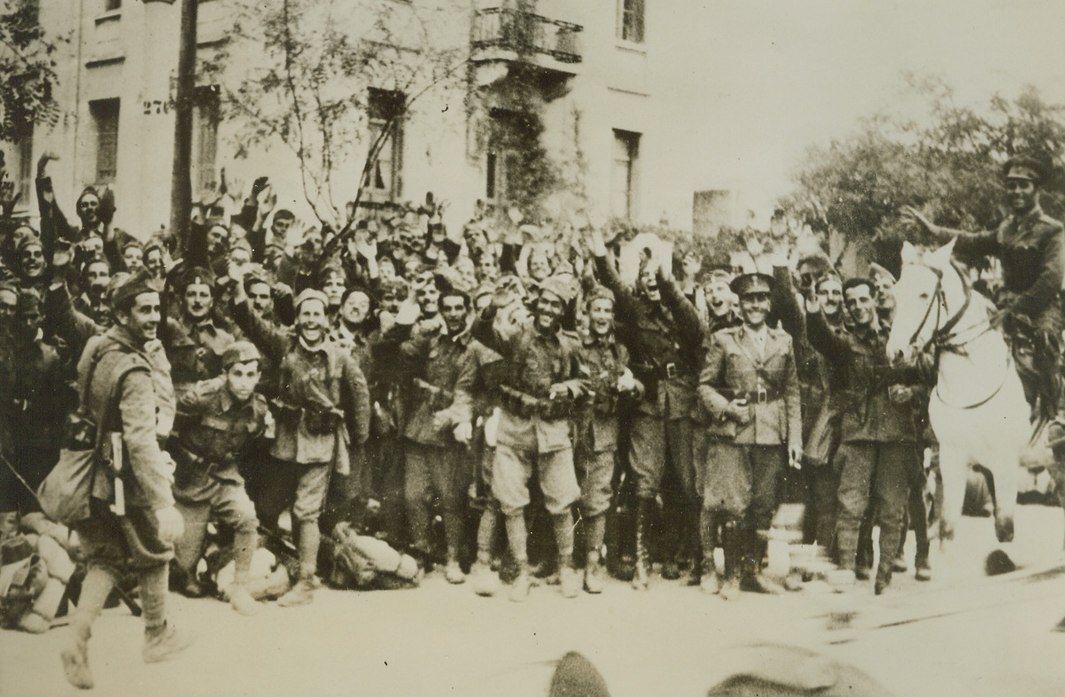 THE GALLANT GREEKS, 1/25/41  GREECE—Enthusiastic Greek soldiers cheering just before they left for the front to aid the campaign in Albania against Italy. This superb morale is typical of the victorious Greek forces. Credit: Acme;
