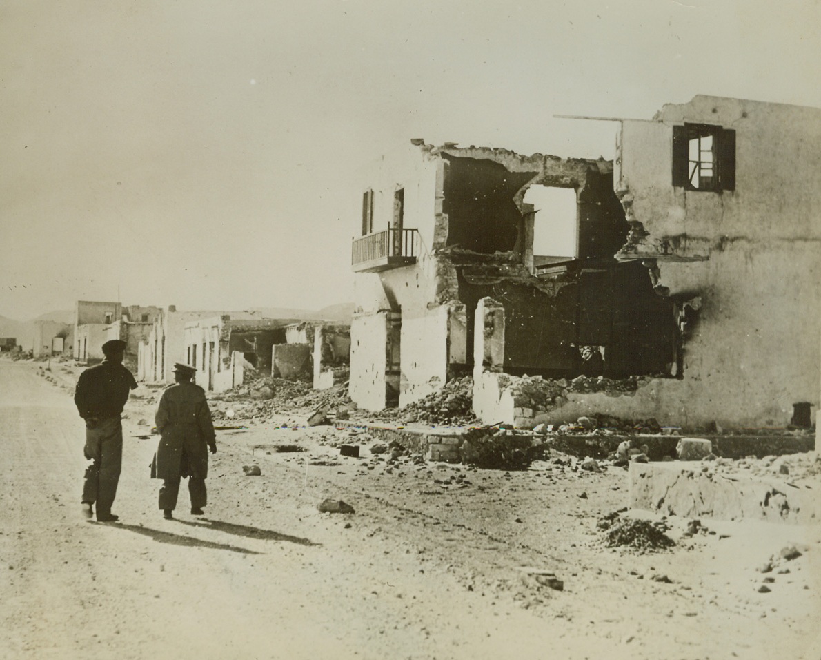 After Sollum Fell to British, 1/25/41  Sollum – British soldiers survey the battered ruins of Sollum, one of the Italian strongholds taken in the British sweep from Egypt into Lybia.  Credit line (ACME);