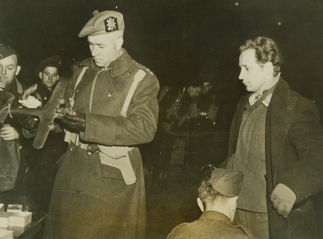 War Prisoners Reach Canadian Shores, 1/27/41  Several hundred prisoners captured by the British arrived at an East Canadian port and were put on trains for Canadian internment camps. In above photo a guard examines a model airplane taken from a prisoner. According to censored caption, these articles are usually returned. Credit: ACME;
