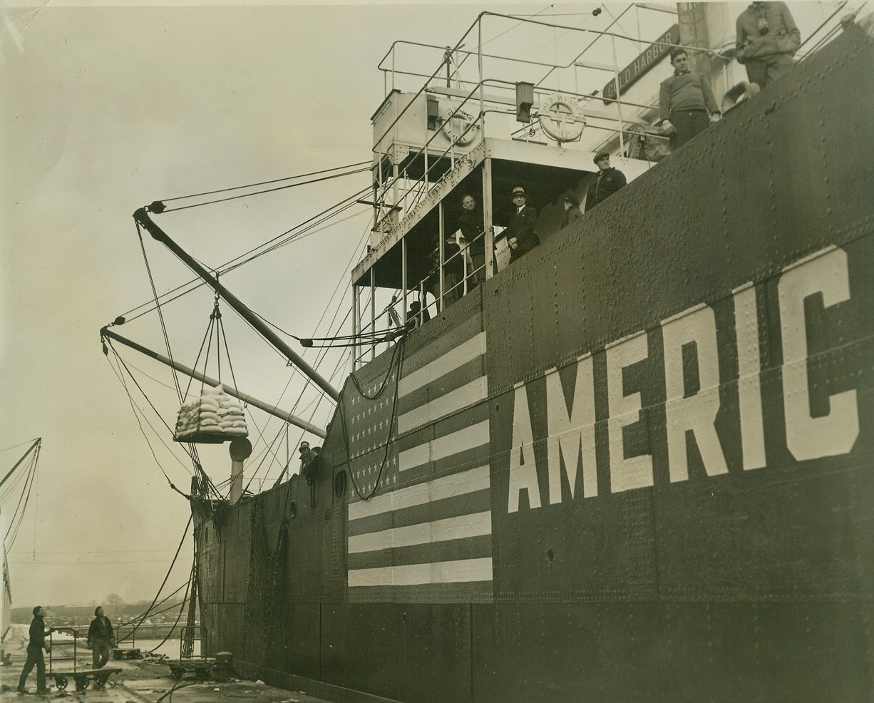 RED CROSS SHIP LOADS SUPPLIES FOR FRANCE, SPAIN, 1/28/41  BALTIMORE, MD—Sack of flour are loaded from a barge to the S.S. Cold Harbor, Red Cross “Mercy Ship” chartered from the United States lines to carry a cargo of relief supplies to Cardiz, Spain, for use in Spain and unoccupied France. The ship, which will pass through the British blockade under special permission of the British Government, will sail from Baltimore on Feb. 1st. Credit: OWI Radiophoto from ACME;
