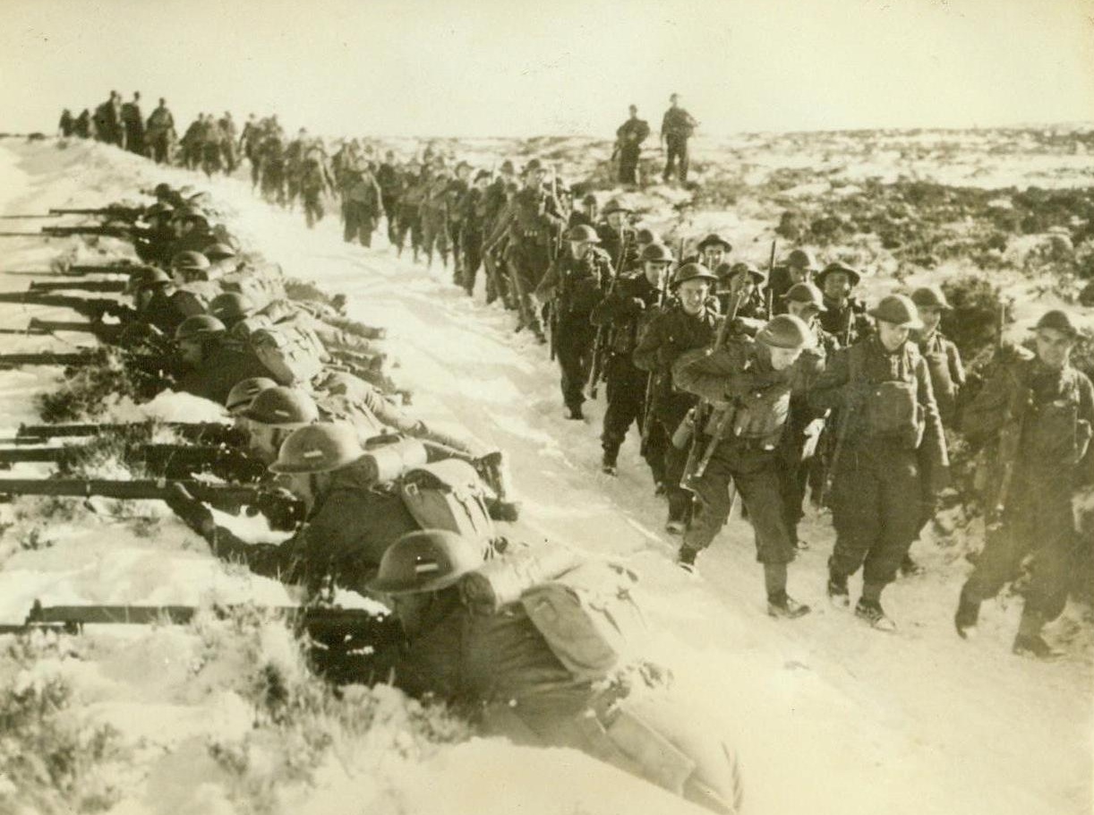 British Troop Train Under Shell Fire, 2/5/41  England -- Troops on the left man a snow-covered sunken road while their mates move into position for an advance during maneuvers in which the troops move up under a living barrage. Britain’s army today trains under real war conditions and part of that training consists of getting the men used to shell fire. Passed by British censor. Credit: ACME;